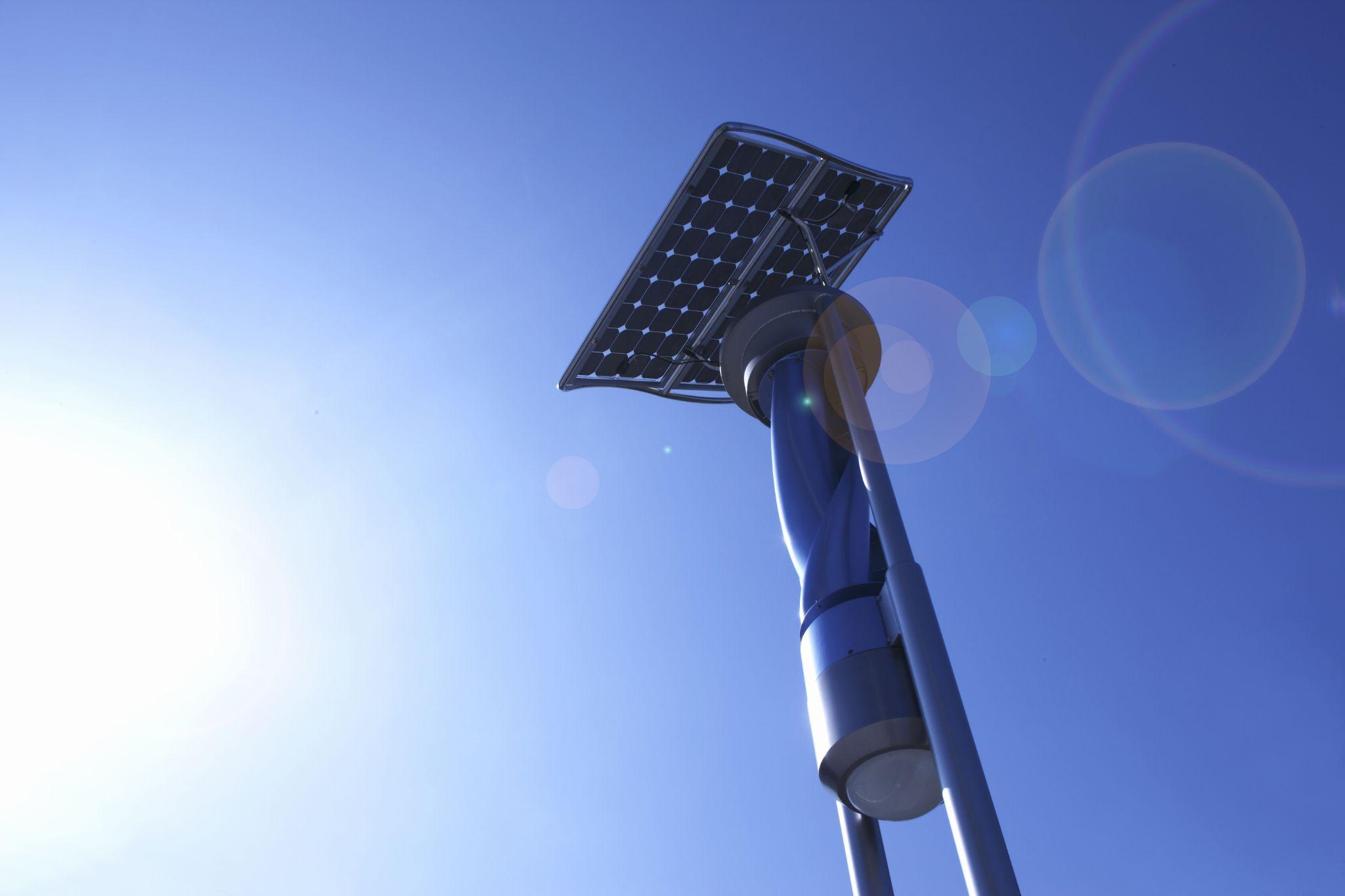 Foto de um poste gerador de energia solar e eólica.